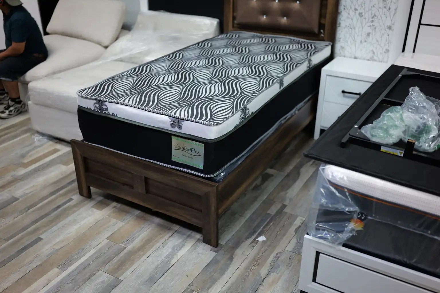 Thick double-sided mattress with gray wave pattern on a wood frame