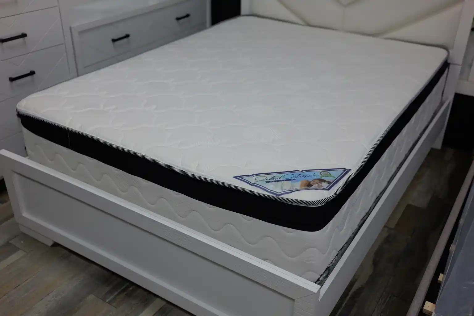 Euro Top mattress with plush white top and black border on a bed frame