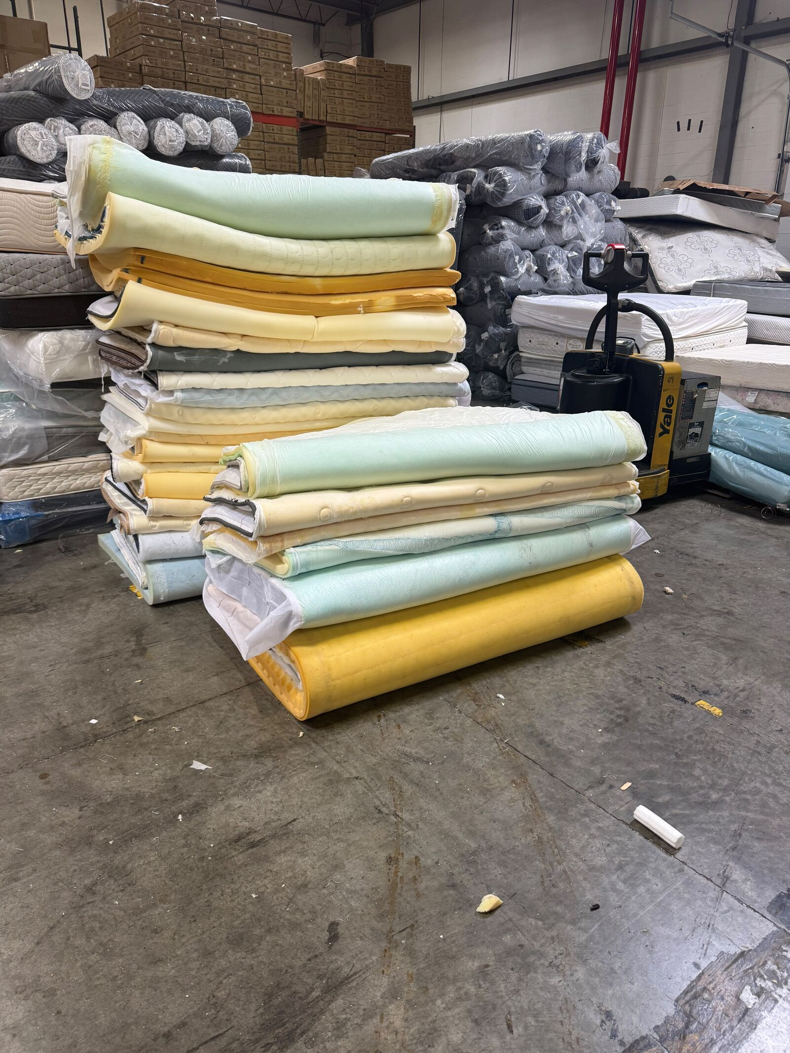 Wrapped mattress inventory stacked inside the Mattress Liquidation USA warehouse